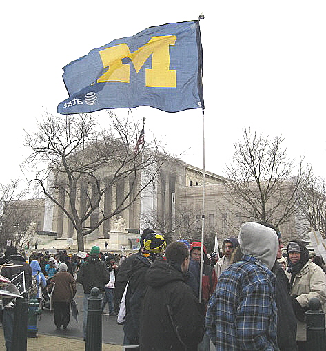 'M' banner and students, with U.S. Supreme Court in background