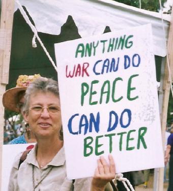 Antiwar protester with sign: 'Anything 
War Can Do/Peace Can Do Better'