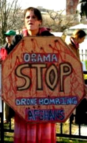 Woman with sign, 
'Obama/Stop Drone Bombing Afghans'
