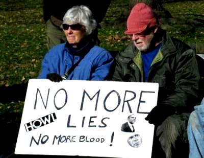 Elderly couple hold sign: 'No More Lies/No More Blood!'