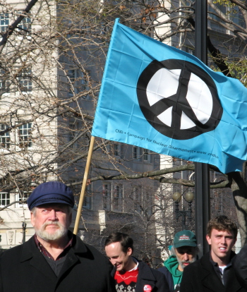 Demonstrators and peace-sign flag