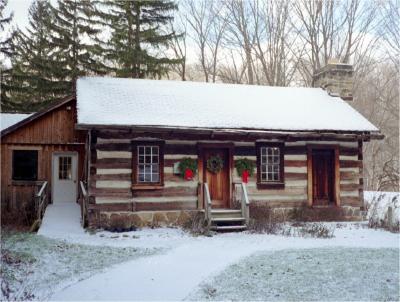 Log cabin with snow on roof