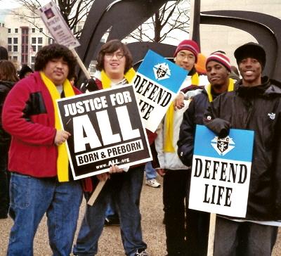 Five young men at March for Life with signs: 'Justice for ALL' and 'Defend Life'