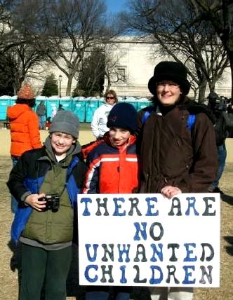 Mother with two boys holds sign 
that proclaims: 'There Are No Unwanted Children'