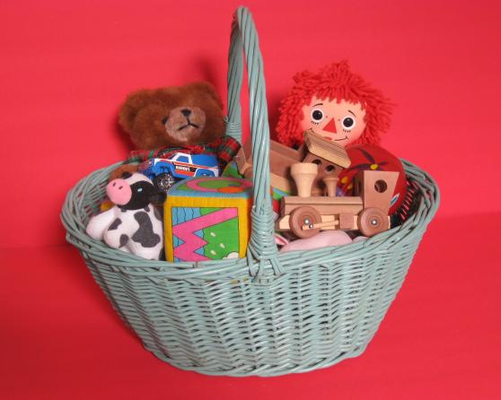 Basket of toys, including a miniature wooden train engine, a Teddy 
Bear, and Raggedy Ann
