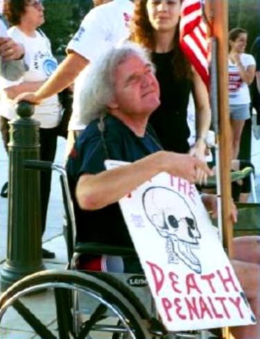 Protester in wheelchair carries anti-death penalty sign