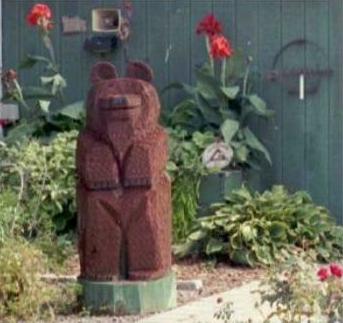 Mini-garden with large wooden bear